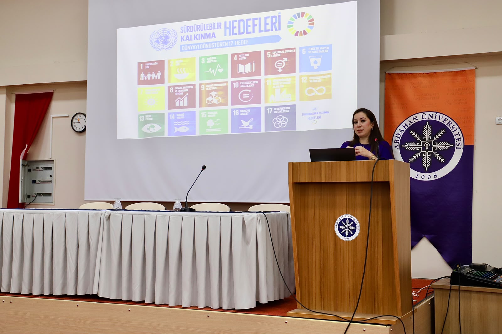 Görselde, Üniversitemiz Öğretim Üyesi Doç. Dr. Bilge Sayın kürsüde sunum gerçekleştirmektedir.